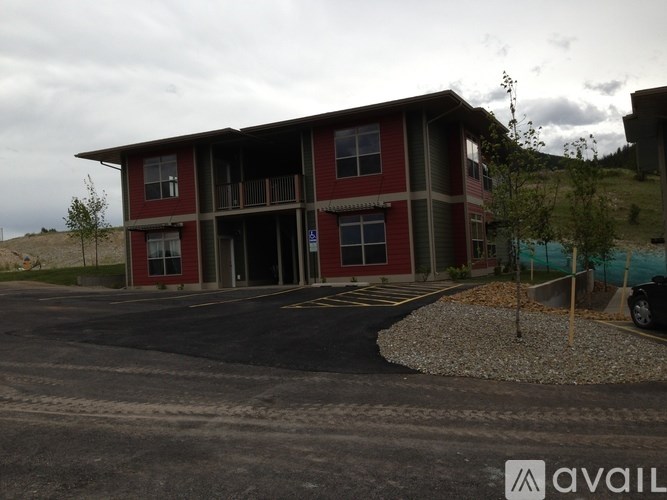A red and brown building with a parking lot in front.