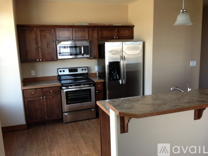 A kitchen with a refrigerator, oven, and microwave.