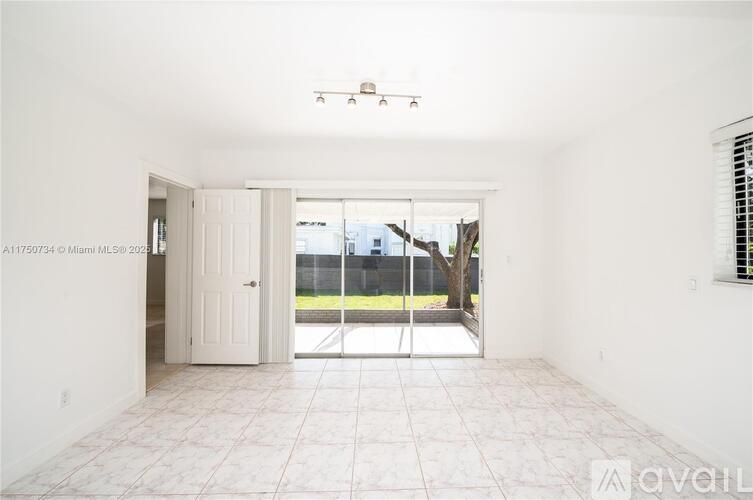 A room with a tiled floor and a sliding glass door leading to a backyard.