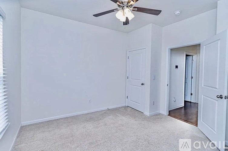 A room with a ceiling fan and two doors.