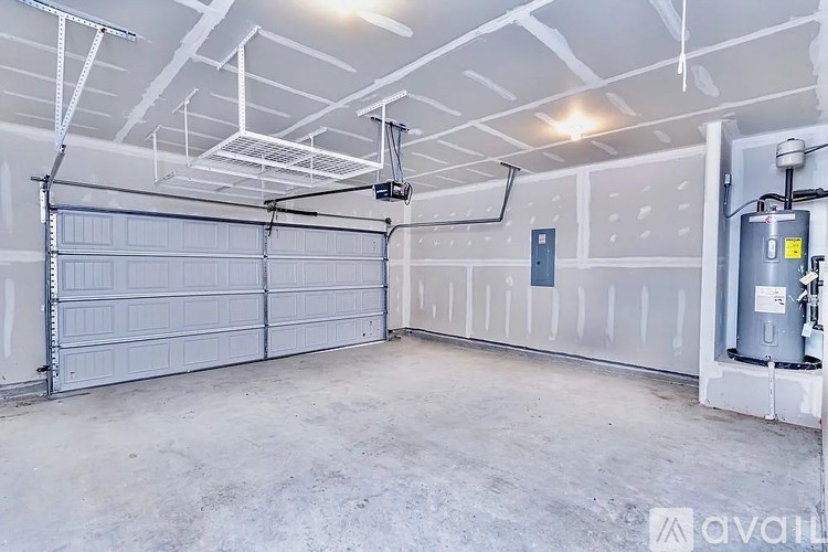 A spacious garage with a closed white door and a grey floor.