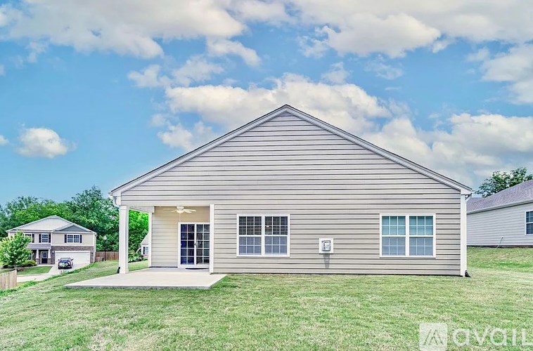 A house with a grey siding and a white roof is shown.