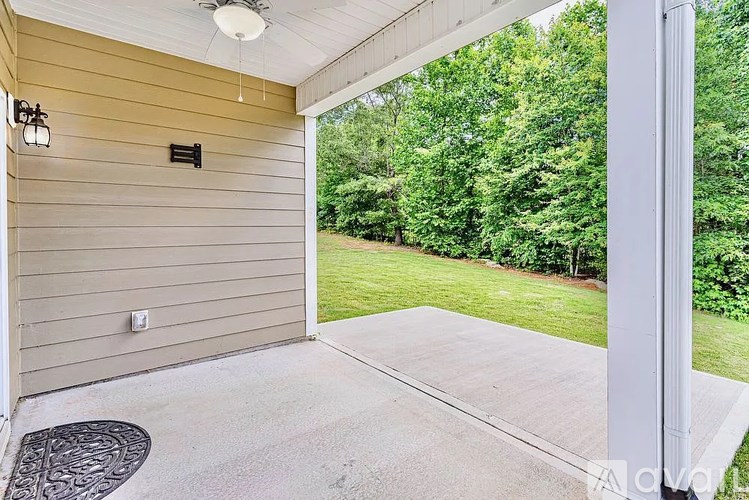 A patio area with a concrete floor and a white pillar.