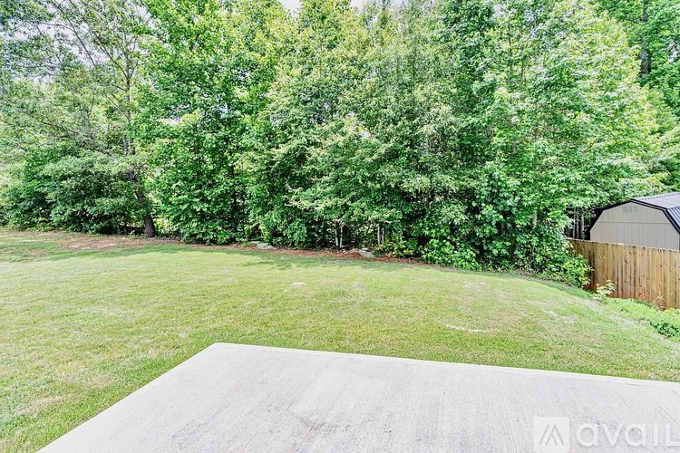 A backyard with a concrete slab and a wooden fence.