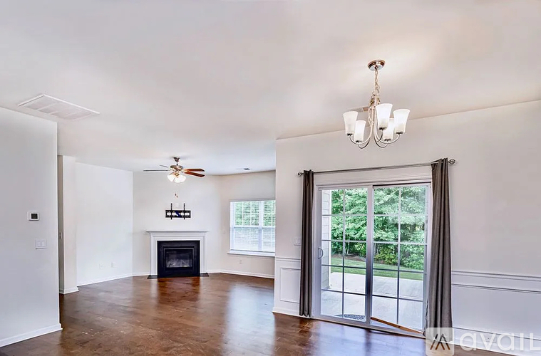 A spacious living room with a fireplace and sliding glass doors.