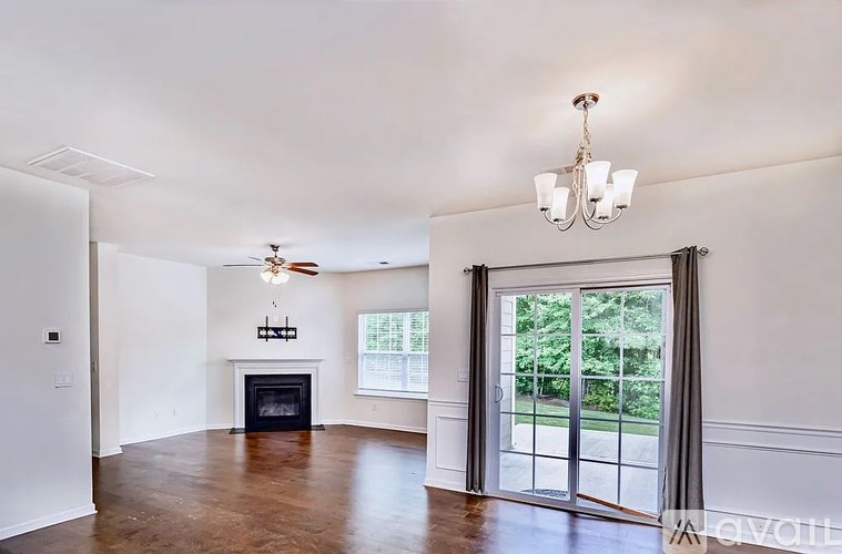 A spacious living room with a fireplace and sliding glass doors.