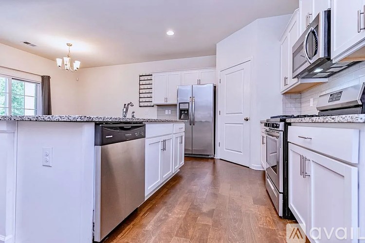 A kitchen with white cabinets and stainless steel appliances.