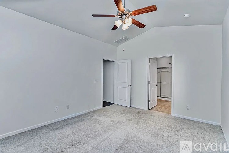 A room with a ceiling fan and two doors.