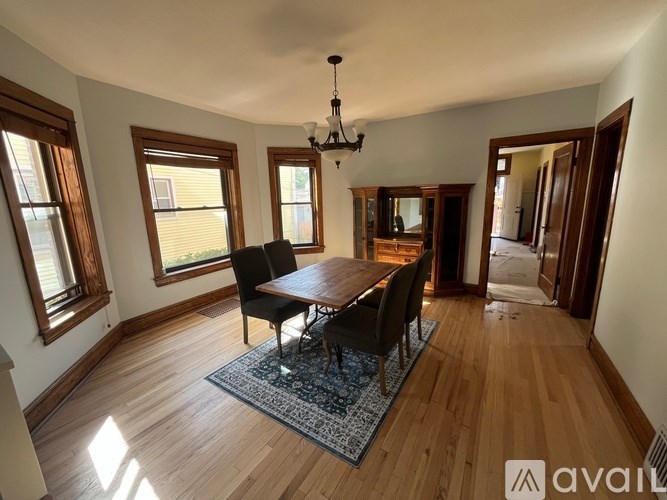 A dining room with a wooden table and chairs.