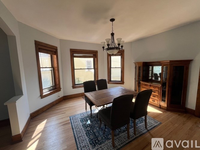 A dining room with a wooden table and chairs.