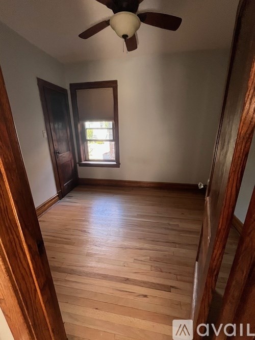 A room with wooden floors and a ceiling fan.