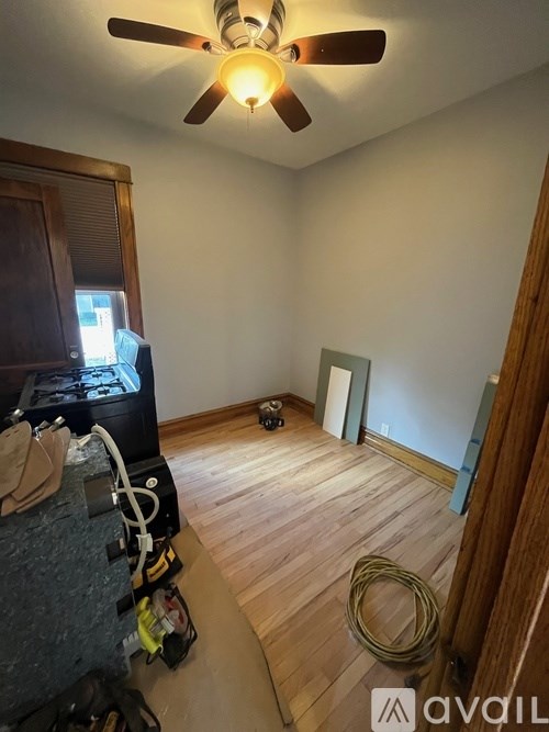 A room with a ceiling fan and a ring on the floor.