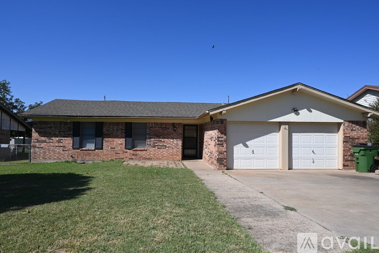 A house with a garage and a green lawn in front.
