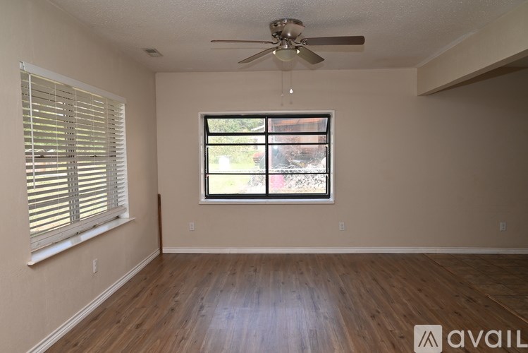 A room with a window and a ceiling fan.
