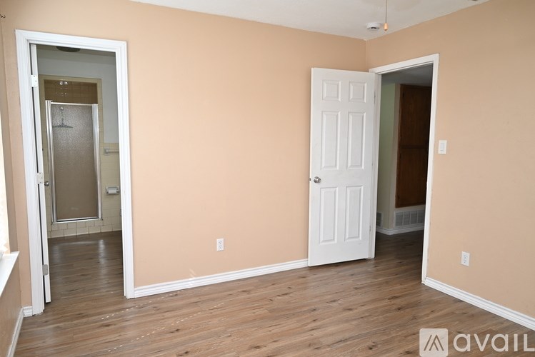 A room with a white door and a white cabinet in the corner.