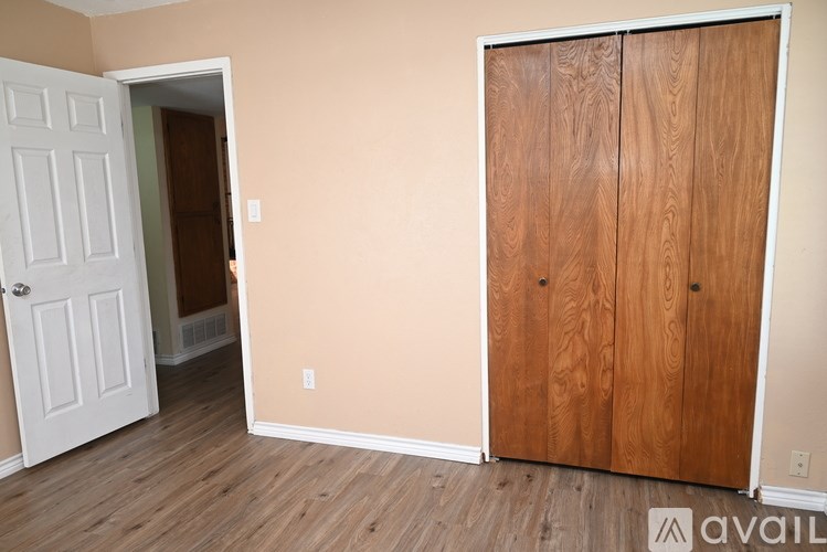 A room with a white door and a wooden door.
