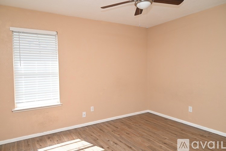 A room with a window and a fan on the ceiling.