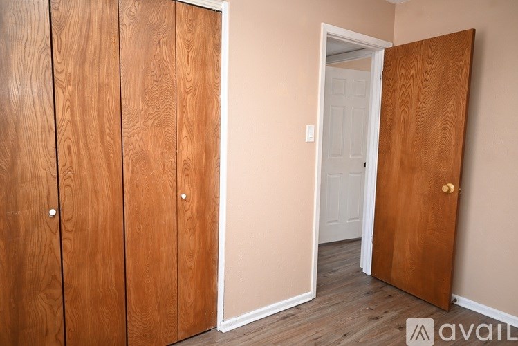 A room with a white door and a wooden wardrobe.