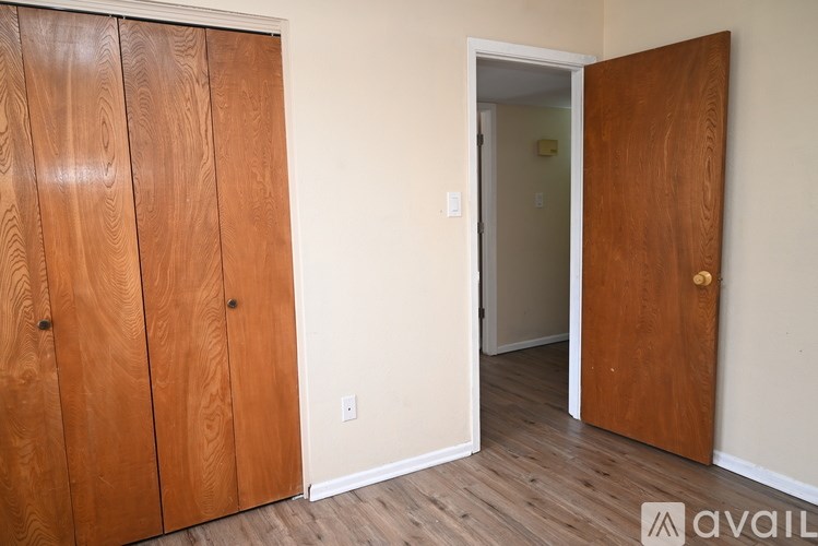 A room with a wooden door and a wooden cabinet.