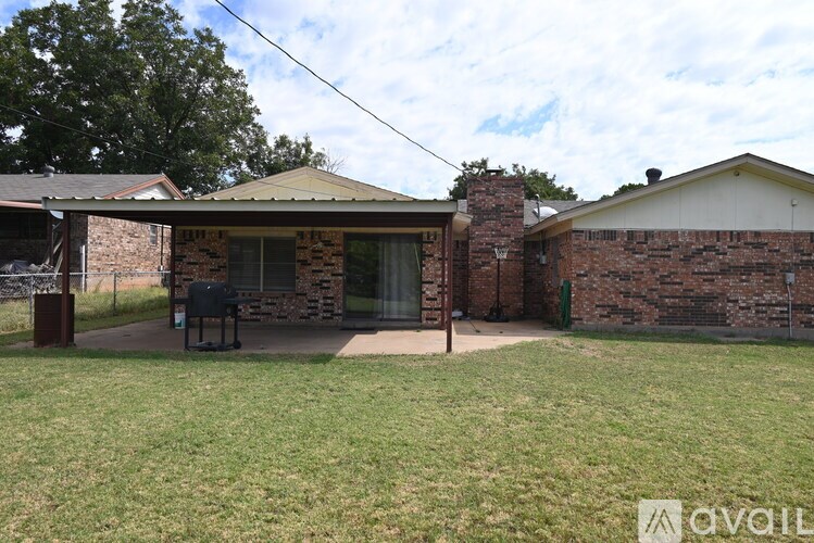 A house with a covered patio and a lawn in front.