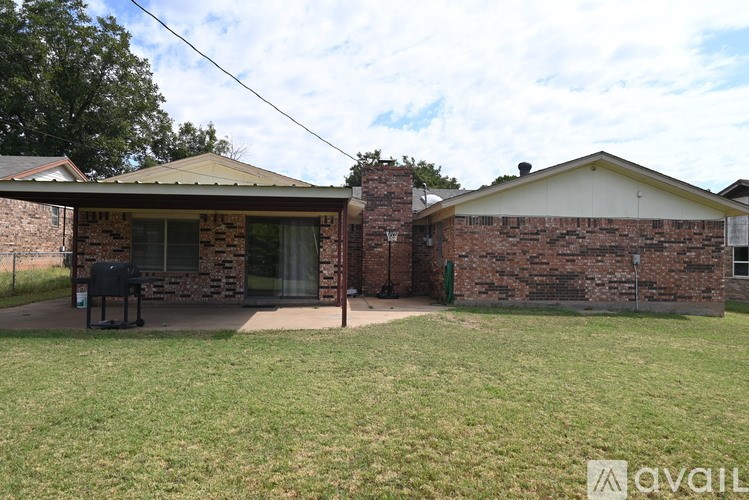 A house with a covered patio and a lawn.