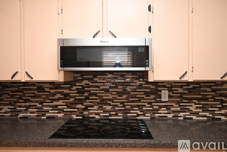 A kitchen with a microwave oven mounted above a stove.