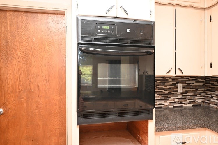 A black oven with a digital display is built into a kitchen counter.