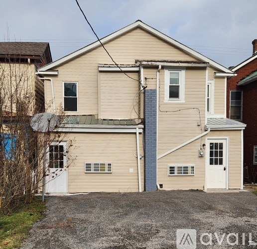 A two-story house with a garage and a driveway.
