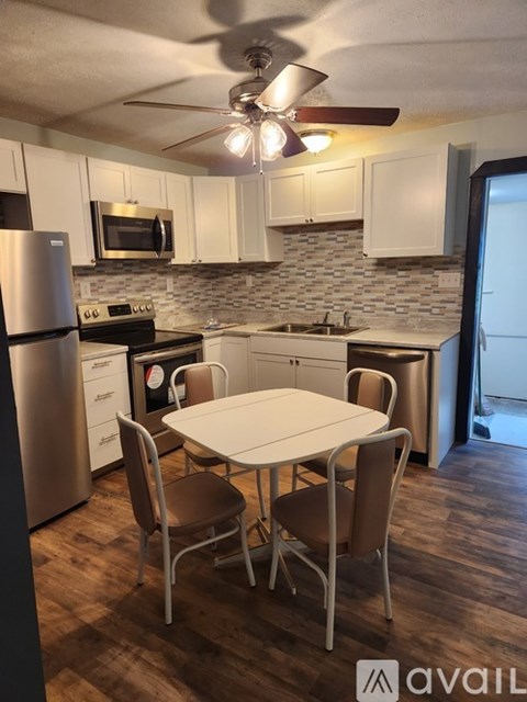 A kitchen with a table and chairs.
