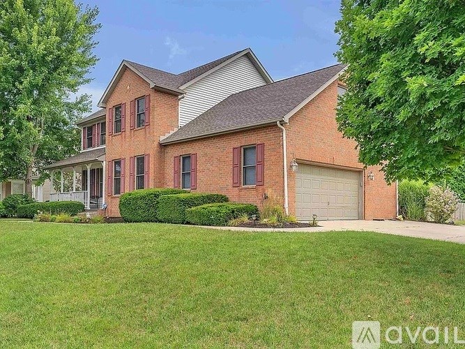 A brick house with a garage door and a driveway.