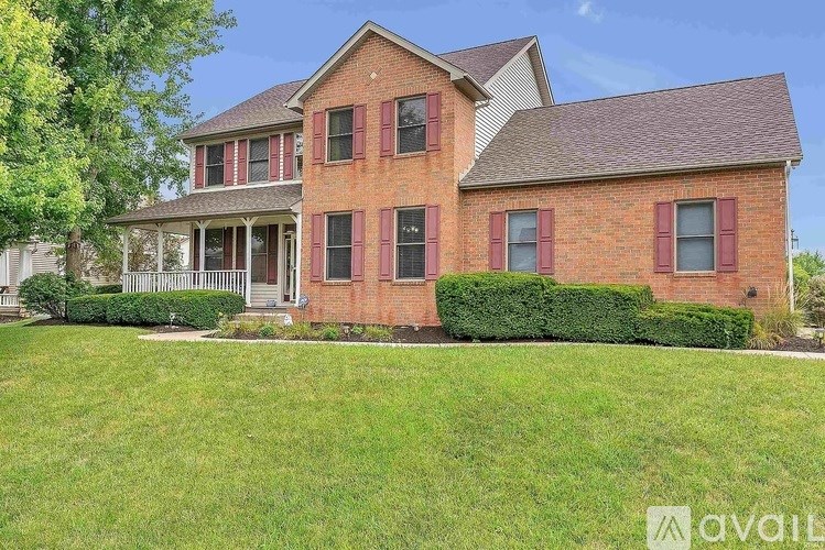 A brick house with a lawn in front.