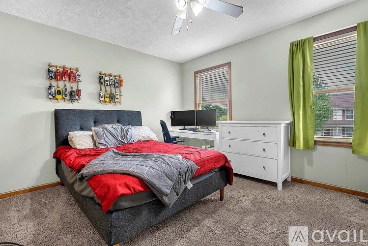 A bedroom with a bed, dresser, and window.