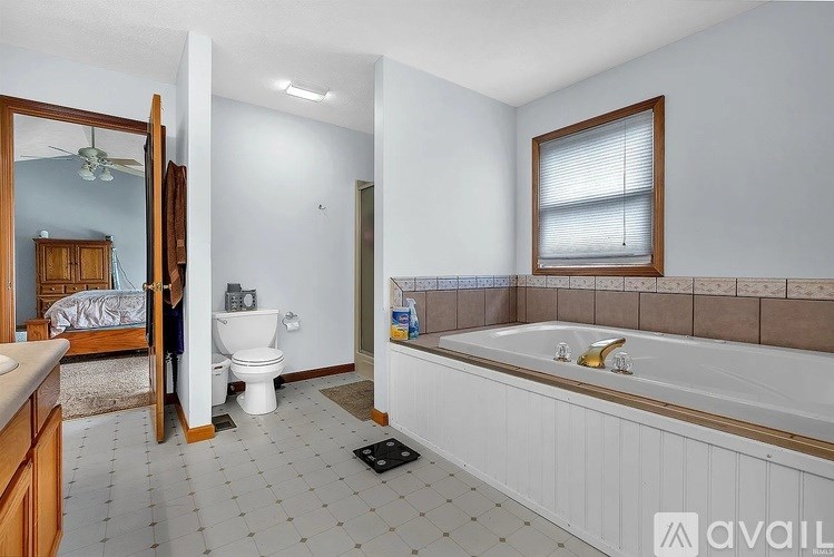A bathroom with a white tub, toilet, and sink.