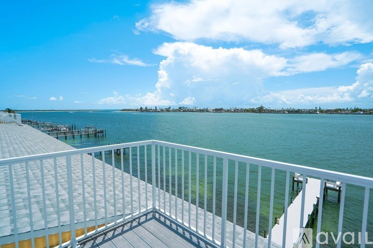 A white railing overlooks a body of water.