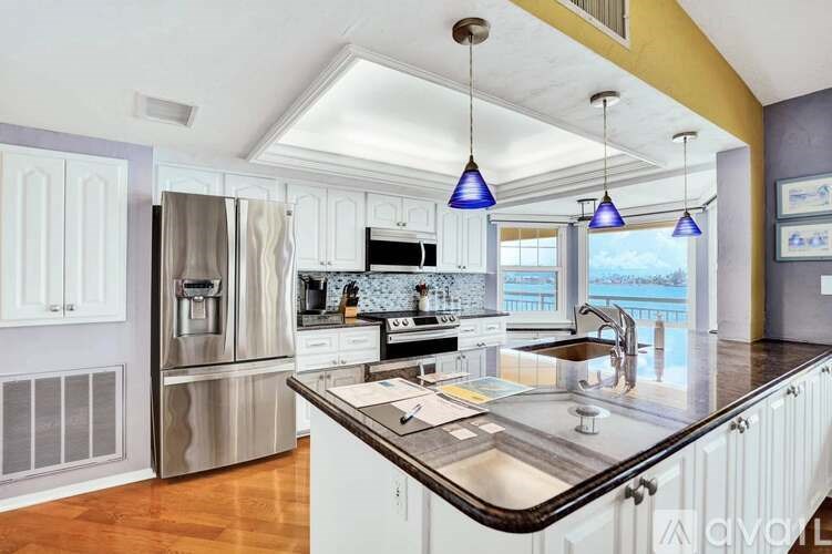 A kitchen with a stainless steel refrigerator and a sink.