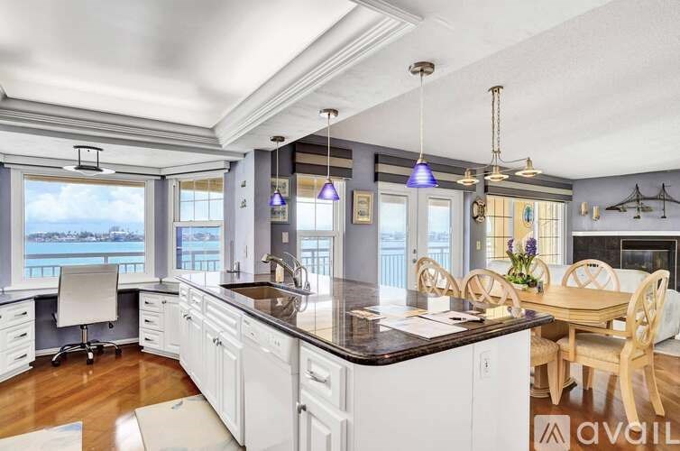 A kitchen with a large island and a dining table.