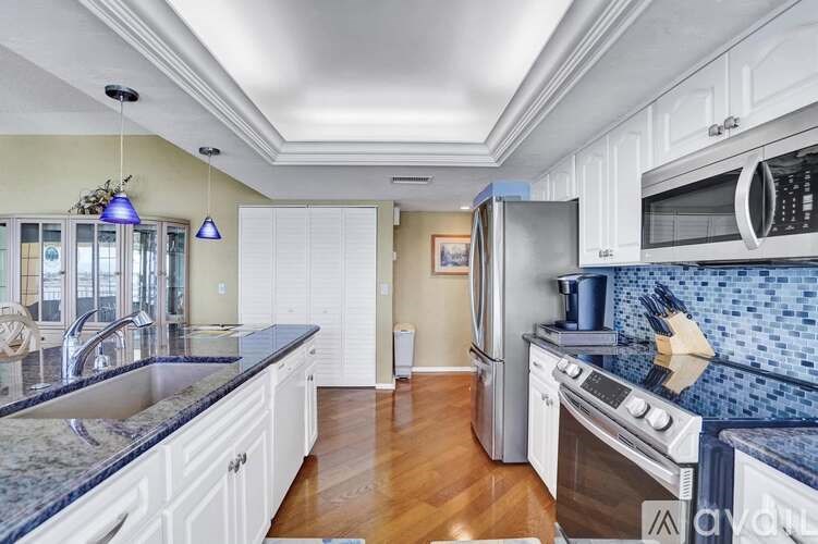 A kitchen with white cabinets and a blue backsplash.