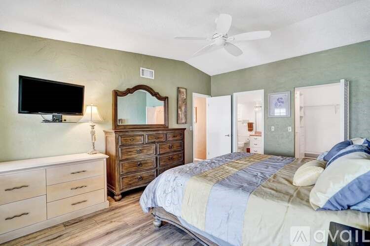 A bedroom with a bed, dresser, and mirror.
