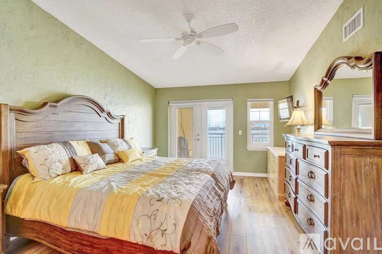 A bedroom with a large bed and a dresser.