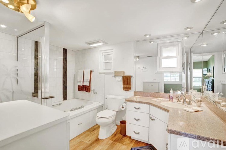 A bathroom with a white tub, toilet, and sink.