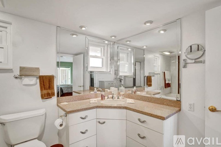 A bathroom with a marble countertop and a large mirror.