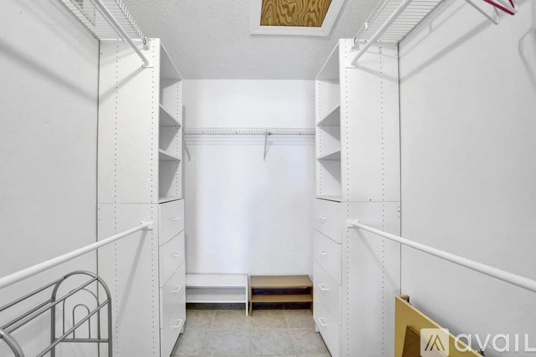A white pantry with a bench and a metal railing.