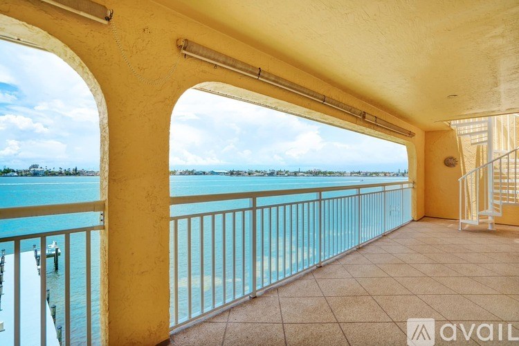 A balcony with a yellow railing overlooking a body of water.