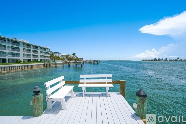 A wooden bench sits on a dock overlooking a body of water.