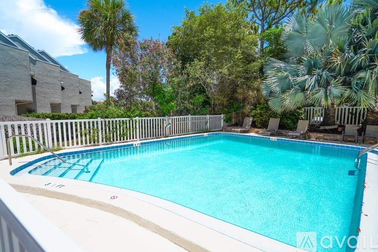 A small pool surrounded by a white fence.
