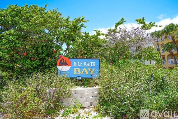 A sign that says Blue Water Bay is surrounded by greenery.