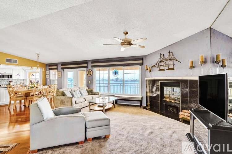 A living room with a grey sofa and a fireplace.