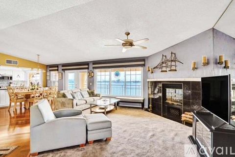 A living room with a grey sofa and a fireplace.