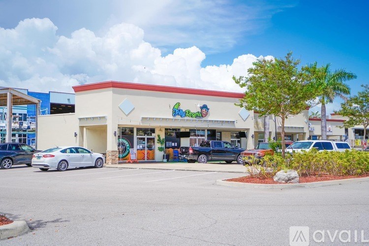 A car is parked in front of a store with a red roof.