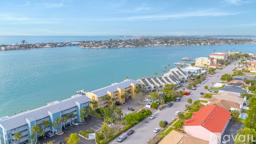 A view of a coastal area with apartment buildings and a parking lot.